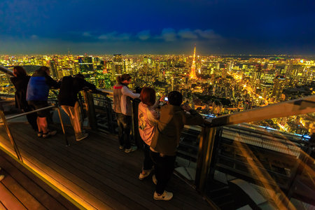 Tokyo, Japan - April 20, 2017: people take pictures of Tokyo Skyline and Tokyo Tower from atop of Mori Tower in Roppongi Hills complex, Minato District, Tokyo, Japan.のeditorial素材