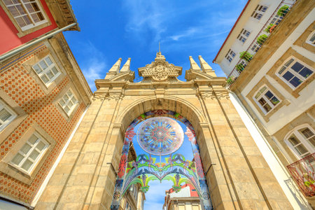 Braga, Portugal - August 12, 2017: Perspective view of Arco da Porta Nova, looking east along Rua Dom Diogo de Sousa. Arch of the New Gate in Baroque style city gate, part of the Braga city walls.のeditorial素材