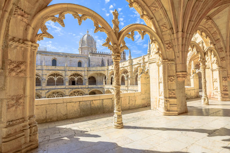 Beautiful reticulated vaulting on courtyard or cloisters of Hieronymites Monastery, Mosteiro dos Jeronimos, famous Lisbon landmark in Belem district and Unesco Heritage. Church dome on background.のeditorial素材