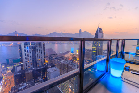 Hong Kong, China - January 1, 2016: spectacular aerial view of Victoria Harbor skyline at sunset from the rooftop of Eye Bar, a modern skybar inside iSquare shopping center in Kowloon, Hong Kong city.のeditorial素材