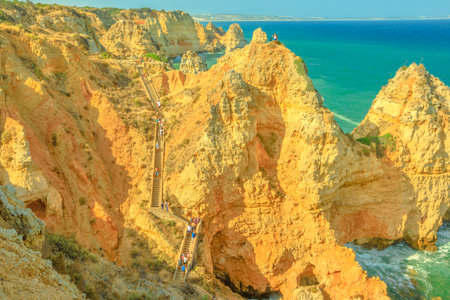 Lagos, Portugal - August 22, 2017: people walk the long staircase composed of 182 steps leading to the base of cliffs of Ponta da Piedade in Lagos Bay. Famous tourist attraction in Algarve Coast.のeditorial素材