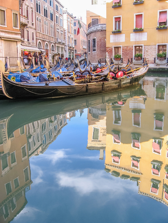 old Venice historic gondolas through Venetian alleys reflected on water canals of the town. Italian site of Unesco Heritage.の写真素材
