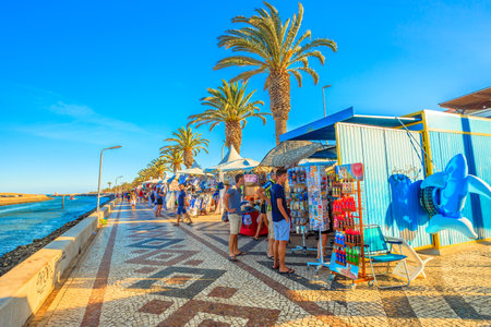Lagos, Portugal - August 19, 2017: market along the Avenida dos Descobrimentos, the boulevard with palm trees on the port of Lagos. Tourists do shopping in summer season.のeditorial素材