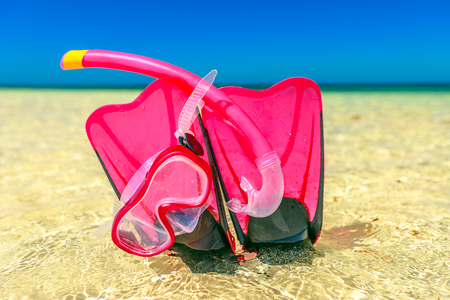 Close-up of scuba mask with fins in pink color on the sand of Hangover Bay in Nambung National Park, Western Australia. Blue sky. Summer equipment for snorkeling.の写真素材
