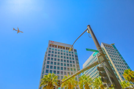 San Jose, United States - August 12, 2018: Adobe crossroad with an airplane flying on top from San Jose. Adobe is leader in software for graphic, photography, video making and a big microstock agency.のeditorial素材