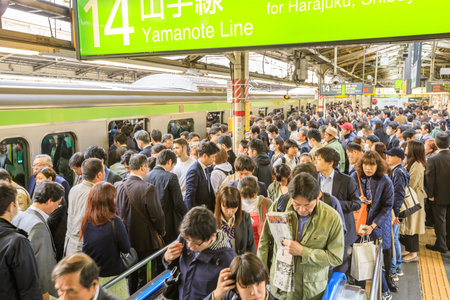 Tokyo, Japan - April 17, 2017: green line of Yamanote for Harajuku, the most important train line in Tokyo. Crowd of commuters waiting for rail train at Shinjuku Station in Tokyo.のeditorial素材