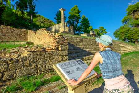 Tourist woman reading explanation of popular Archaeological Site. Mediterranean travel destination....