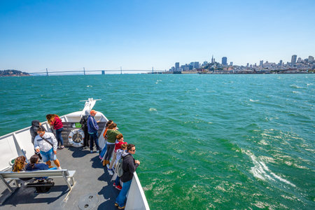San Francisco, California, United States - August 14, 2016: Alcatraz Flayer boat tour prow to Alcatraz island with San Francisco cityscape and Oakland Bridge, California in the United States.Blue sky.のeditorial素材