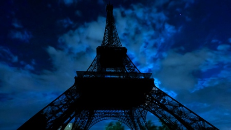 dark sky with clouds, the full moon shining and clouds at night with backlit Eiffel Tower. Paris in France.の写真素材