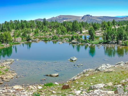 North America road trip. Alpine lake along scenic drive Beartooth Highway, Northeast gateway of Yellowstone National Park. Beartooth Highway, the most beautiful road in America, Wyoming. Summer seasonの写真素材