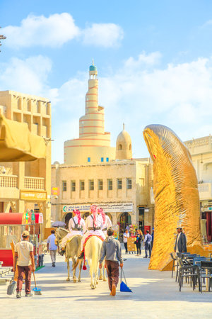 Doha, Qatar - February 20, 2019: two police officers riding white Arabian horses at Souq Waqif....