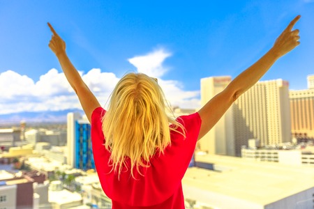 Travel holiday vacation in Nevada, USA. Blonde woman enjoying at Las Vegas skyline casino. Aerial view of cityscape in sunny day with blue sky. Happy lifestyle tourist on the Ferris Wheel.の写真素材