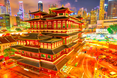 Buddha Tooth Relic Temple of Singapore from aerial view, Southeast Asia. Spectacular buddhist temple in Chinatown district with business district skyline on background by night.の写真素材