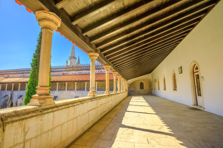 Batalha, Portugal - August 16, 2017: corridor of Batalha Monastery and Church and gothic tower on background. Monastery of Saint Mary of the Victory is inserted into circuit of monastery of Portugal.のeditorial素材