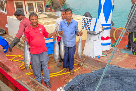 Al Khor, Qatar - February 23, 2019: fishermen on traditional dhow show to big fresh fishs. Al Khor resort near Doha famous for its new Fish Market. Qatar, Middle East, Arabian Peninsula.のeditorial素材
