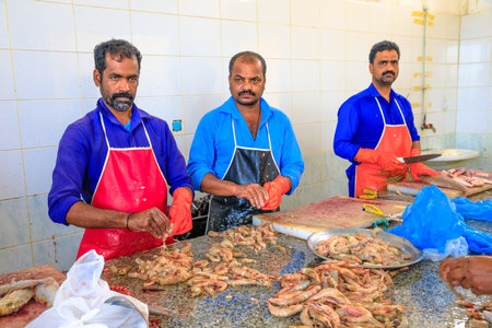Al Khor, Qatar - February 23, 2019: group of workers cleans and fresh shrimp and tuna cuts inside at Al Khor Fish Market located near to corniche in Qatar, Middle East, Arabian Peninsula.のeditorial素材