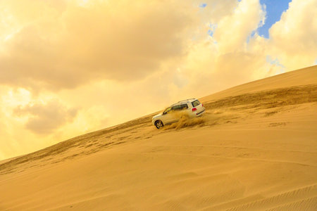 Khor al Udaid, Qatar - February 19, 2019: Off-road adventure with Toyota Land Cruiser in Arabian Desert at sunset. 4x4wd vehicle dunes bashing, inland sea near Saudi Arabian, Persian Gulf, Middle Eastのeditorial素材