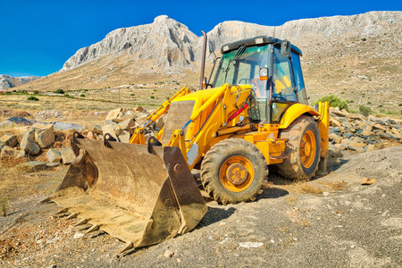Side view of bulldozer on wheels for mines and pits for building work in a suggestive mining site....