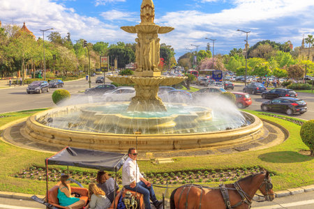 Seville, Andalusia, Spain - April 19, 2016: close-up of horse carriage ride around fountain in Don Juan de Austria Square. Urban cityscape from Touristic Bus. City sightseeing in a sunny day.のeditorial素材
