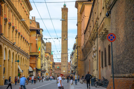 Bologna, Italy - May 9, 2020: Phase 2 Coronavirus after quarantine with social distancing. Lifestyle fashion women with the surgical masks in Via Ugo Bassi road with two towers on the background.のeditorial素材