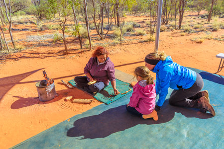 Kings Creek Station, Northern Territory, Australia - Aug 21, 2019: families with children observe variety colorful bush seeds gathered at Karrke Aboriginal Cultural Experience. Famous outback tour.のeditorial素材