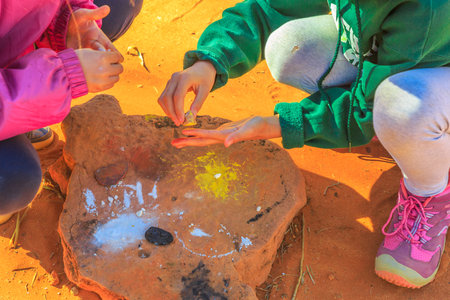 Kings Creek Station, Northern Territory, Australia - Aug 21, 2019: tourists try the Australian aboriginal color painting. Used by Luritja and Pertame people in Central Australia for natual painting.のeditorial素材
