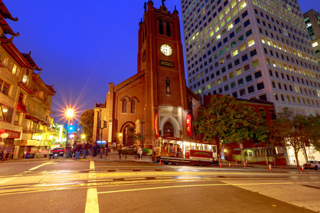 San Francisco, California, United States - August 15, 2019: cable car stops in front of a historic church in San Francisco downtown by night. Light trails of cars in city Californian nightlife.のeditorial素材