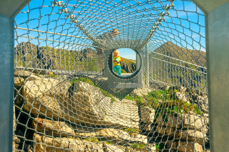 Birg, Murren, Switzerland - Aug 19, 2020: child walks the tube made of nets of Thrill walk on...