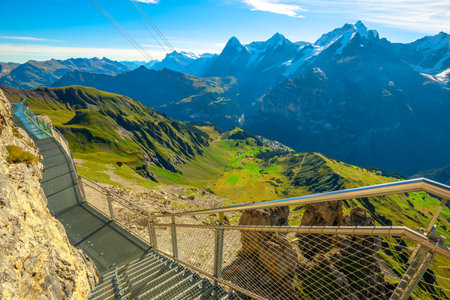 Crystal floor suspended of Thrill walk on Schilthorn, Canton of Bern. Spectacular landscape with snow-capped peaks of Bernese Prealps at Birg above Murren in Switzerland. Summer season, clear blue skyの写真素材