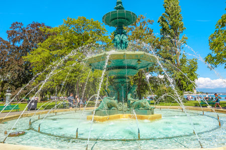 Geneva, Switzerland - Aug 15, 2020: Fountain of Four Seasons in center of Jardin Anglais and promenade du Lac. Geneva Lake, waterfront and bay on background.のeditorial素材