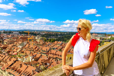 Happy tourist girl looking Bern old town, capital of Switzerland, from panoramic terrace of Bell...