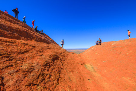 Uluru, Northern Territory, Australia - Aug 23, 2019: people climbing on the top of Ayers Rock before October 2019 when the climb will be closed. Uluru - Kata Tjuta is sacred for Anangu people.のeditorial素材