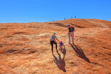 Uluru, Northern Territory, Australia - Aug 23, 2019: family with children climbing on the top of Uluru before October 2019 when the climb will be closed. Uluru - Kata Tjuta is sacred for Anangu peopleのeditorial素材