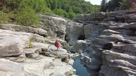 Photographer woman taking pictures with camera in Aussichtspunkt canyon of Ponte Brolla bridge in...