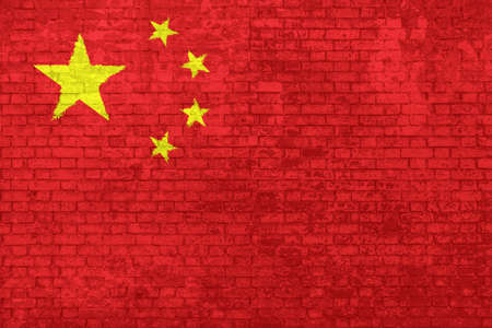 wall of bricks painted with the Chinese flag with five yellow stars on red background. Concept of social barriers of immigration, divisions, and political conflicts in China.の写真素材
