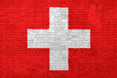 Wall of bricks painted with the national Switzerland flag in 3d background. Concept of social barriers of immigration, divisions, and political conflicts in Switzerland.の写真素材