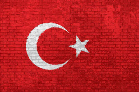 Wall of bricks painted with the national flat flag of Turkey. red color with star and half moon, 3d background. Concept of social barriers of immigration, divisions, and political conflicts in Turkey.の写真素材
