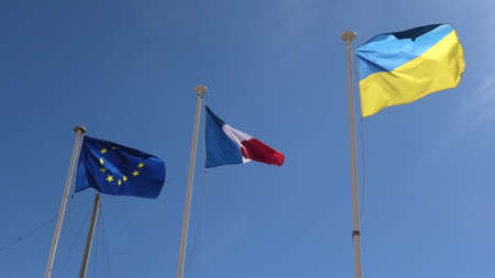 The Ukraine flag and European flag with France flag united in support of the invasion of Ukraine and its joining the European Union. isolated on blue sky background.の写真素材