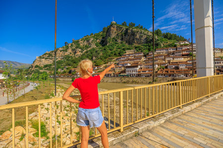 Aerial view of a girl tourist visiting Berat city, a UNESCO World Heritage Site, primarily for its exceptional examples of Ottoman architecture and its unique urban layout.の写真素材