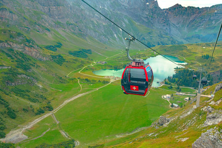Titlis, Engelberg, Switzerland - Aug 27, 2020: Scenic Ride Cable Car adventure over Engelberg Valley, Truebsee Lake, and Titlis Mountain in Uri Alps. Explore Obwalden and Bern Cantons in summer.のeditorial素材