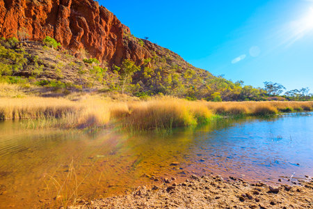 Glen Helen Gorge with sunrays and waterhole in Central Australian outback. West MacDonnell Ranges...