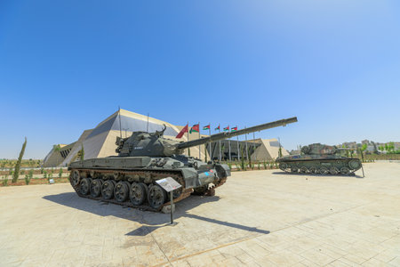 Royal Tank Museum, Amman, Jordan - May 4, 2024: Panzer 61 Swiss battle tank exhibited outdoors with informational panels, against a backdrop of the Royal Tank Museum in Jordanのeditorial素材