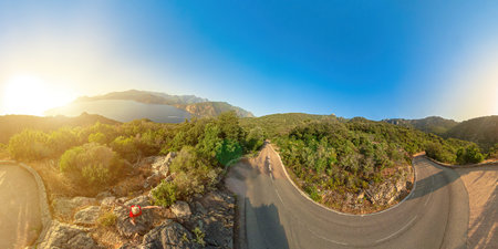 Aerial 360 view of tourist woman on the Calanques of Piana badlands at sunset by the D81 route....