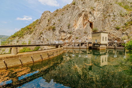 Concrete dam wall curving along Canyon wall holding back green waters of Matka lake, providing hydroelectric power and scenic beautyの写真素材