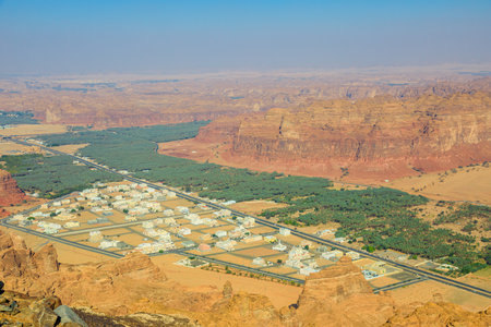 Breathtaking aerial view capturing AlUla Old Town nestled among Saudi Arabias dramatic desert landscapes, featuring sandstone cliffs and lush palm groves from Harrat Viewpointの写真素材