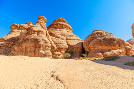 Jabal Ithlib sandstone formations the Diwan and the Siq in Hegra, Al-Ula, Saudi Arabia, showcasing the power of natures artistry and creating a captivating scene under the clear blue skyの写真素材