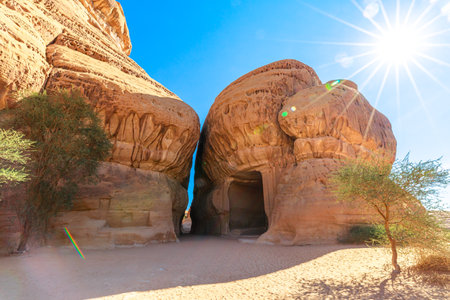Sunlight illuminates Jabal Ithlib, Diwan and the Siq rock-cut tombs in Hegra, Al-Ula, Saudi Arabia, showcasing the ancient Nabataean architecture and the stunning desert landscape in Saudi Arabiaの写真素材