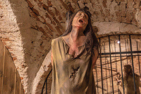 Transylvania, Romania - Oct 8, 2025: Mannequin depicting a victim suffering on hot coals in a historical torture chamber exhibit, Corvin Castle, Hunedoara, Romaniaのeditorial素材