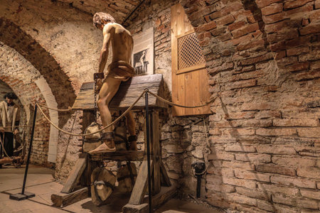 Transylvania, Romania - Oct 8, 2025: Mannequin representing a victim enduring a public torture device, showing historical brutality in a medieval castle museum of Corvin Castleのeditorial素材