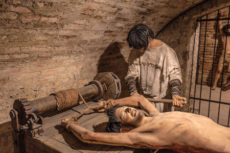 Transylvania, Romania - Oct 8, 2025: Mannequins depicting a prisoner on a rack and an executioner in the torture chamber museum at Corvin Castle, Hunedoara, Romaniaのeditorial素材